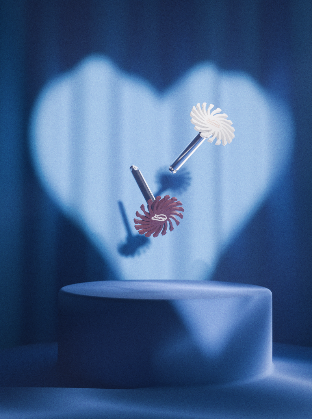 Key visual Saint-Valentin Komet 2026, coeur de lumière et deux polissoirs en lévitation sur fond bleu